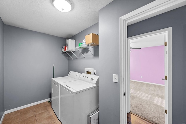 laundry room featuring independent washer and dryer, a textured ceiling, and light tile patterned floors