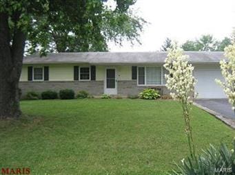 single story home featuring a front lawn and a garage