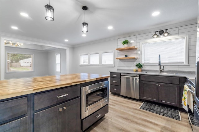 kitchen with a wealth of natural light, stainless steel appliances, hanging light fixtures, and sink