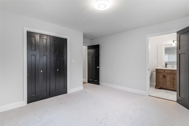 bedroom featuring light carpet, connected bathroom, and a closet