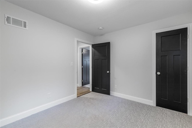 unfurnished bedroom featuring light carpet