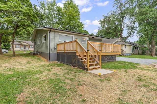 rear view of house featuring a yard and a wooden deck