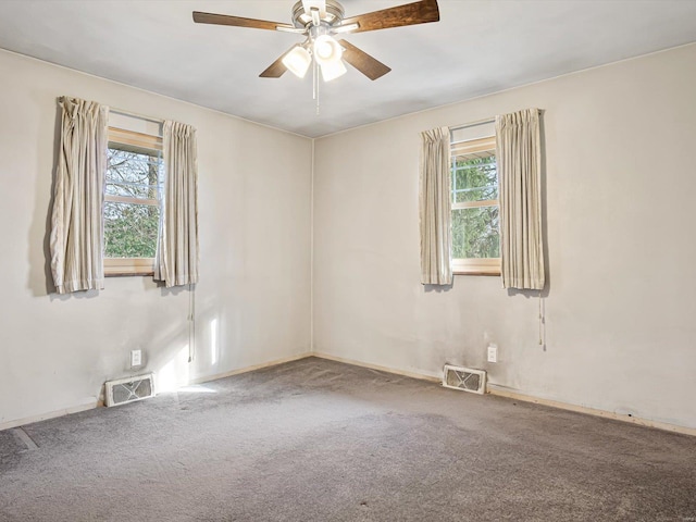 carpeted empty room with ceiling fan and a wealth of natural light