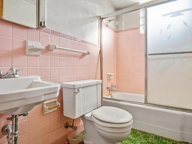 bathroom with toilet, shower / bath combination with glass door, tile walls, and tasteful backsplash