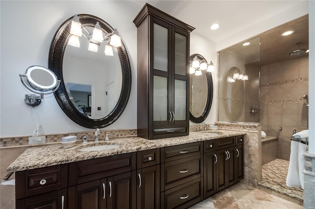 bathroom with tile patterned flooring, vanity, tiled shower, and tile walls