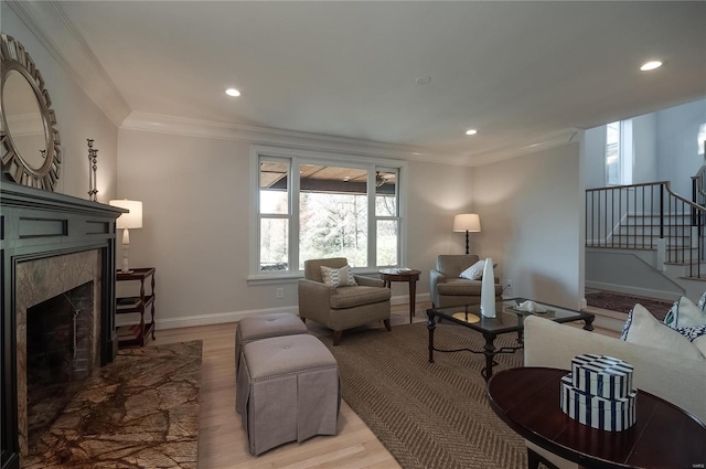 living room with a fireplace, crown molding, and hardwood / wood-style floors