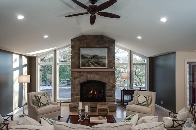 living room featuring a fireplace, plenty of natural light, lofted ceiling, and light wood-type flooring