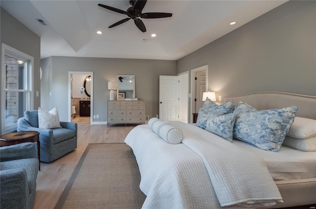 bedroom with ceiling fan, ensuite bathroom, and light hardwood / wood-style floors