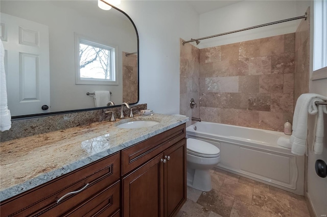 full bathroom featuring vanity, tiled shower / bath combo, and toilet