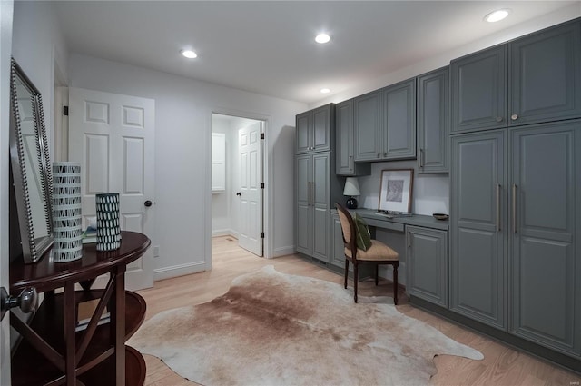 kitchen featuring gray cabinetry, light hardwood / wood-style floors, and built in desk