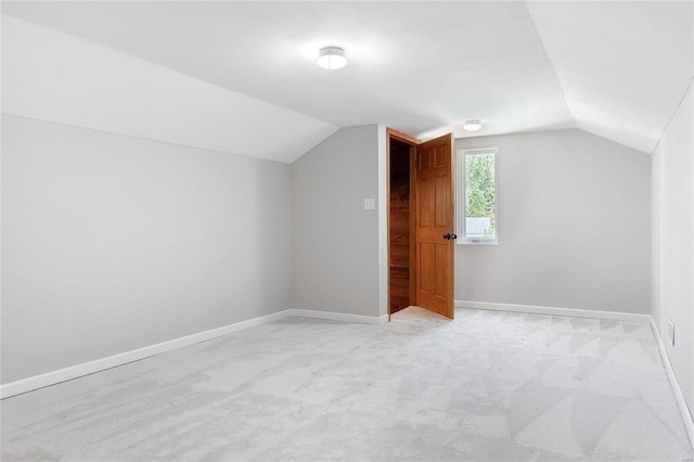 bonus room with light colored carpet and lofted ceiling