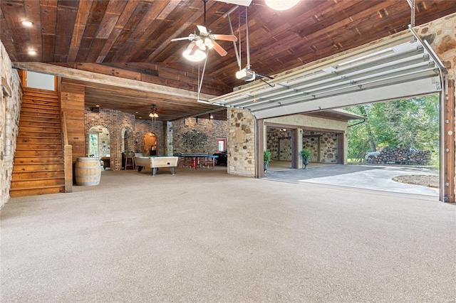 garage featuring a garage door opener, ceiling fan, and wooden ceiling