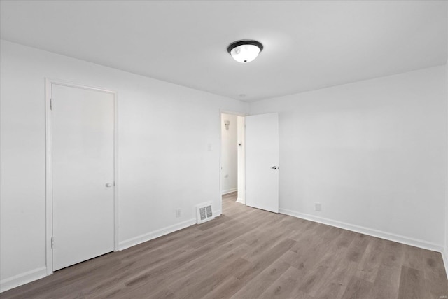 spare room featuring wood-type flooring