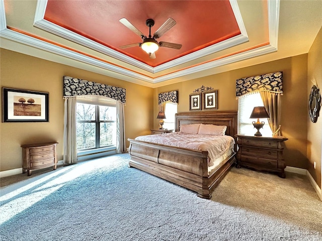 bedroom with carpet, a tray ceiling, and ceiling fan