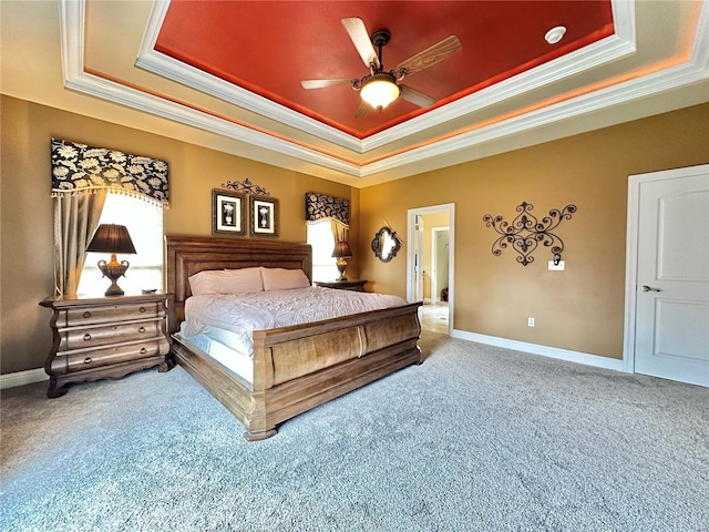 carpeted bedroom featuring a raised ceiling, ceiling fan, and ornamental molding