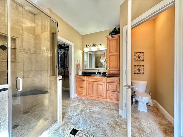 bathroom featuring vanity, a shower with shower door, and toilet