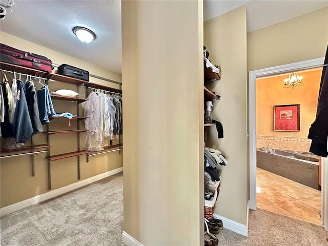 spacious closet featuring carpet floors and a chandelier