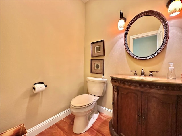 bathroom featuring vanity, hardwood / wood-style flooring, and toilet