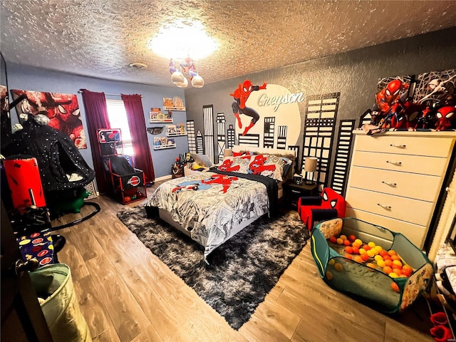 bedroom featuring a textured ceiling and wood finished floors