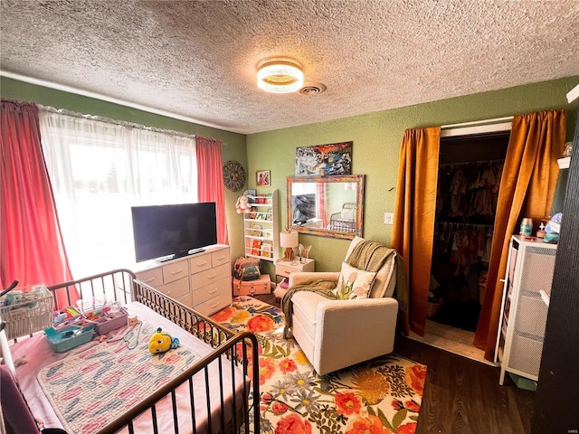 living room featuring a textured ceiling, visible vents, wood finished floors, and a textured wall