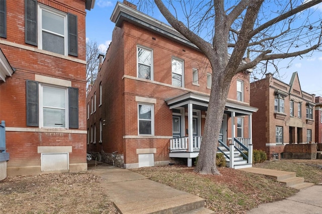 view of front of home featuring brick siding and covered porch