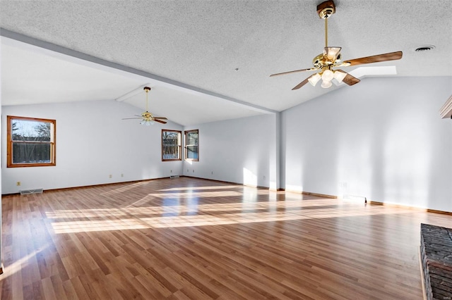 unfurnished living room featuring a textured ceiling, ceiling fan, wood-type flooring, and lofted ceiling