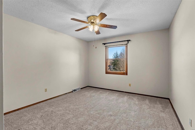 carpeted spare room featuring ceiling fan and a textured ceiling