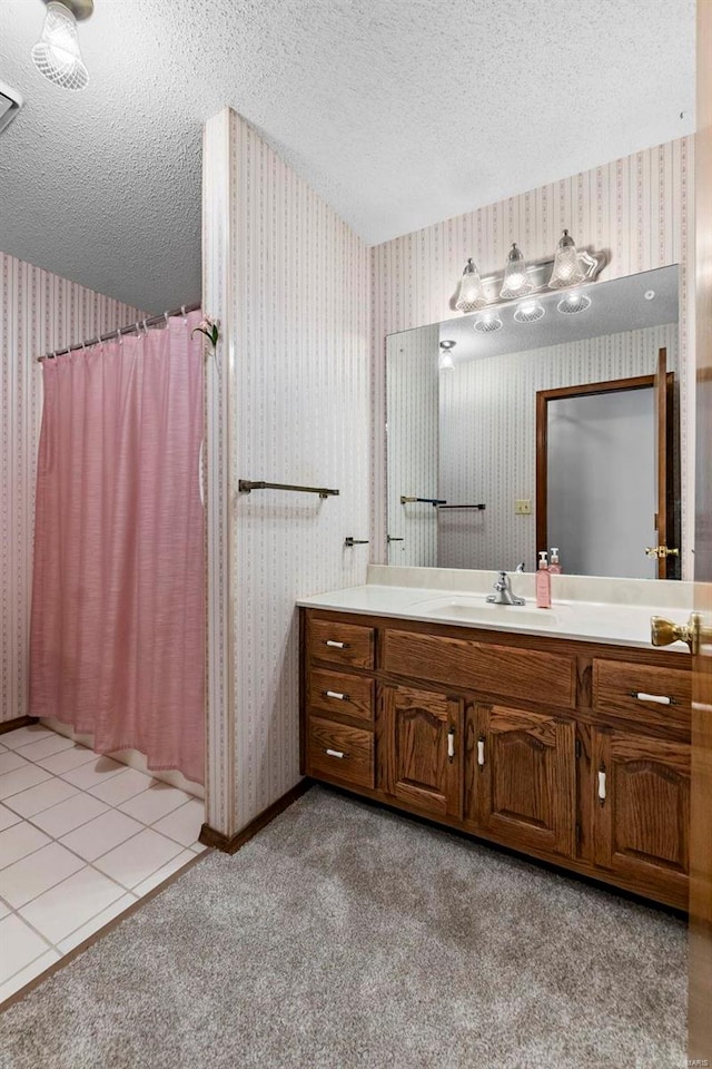 bathroom with tile patterned floors, vanity, a shower with curtain, and a textured ceiling