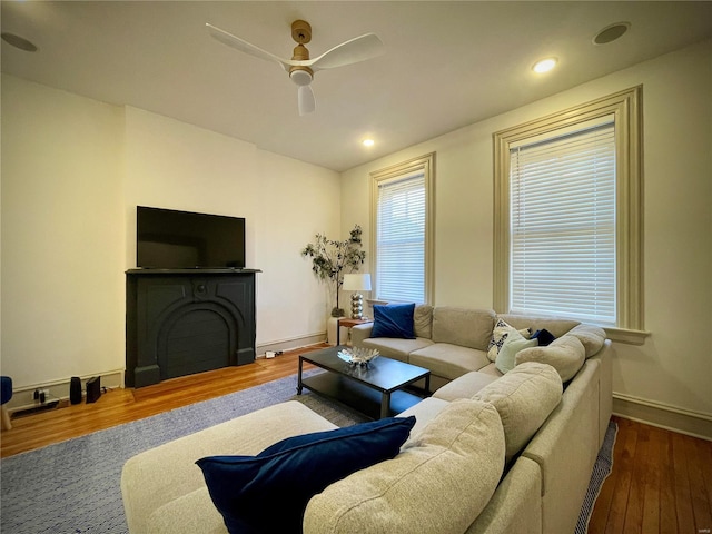 living room with ceiling fan and dark hardwood / wood-style flooring