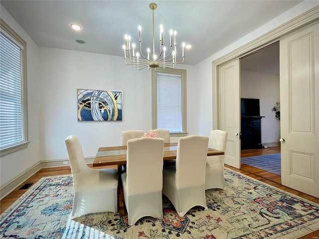 dining space featuring light wood-type flooring and an inviting chandelier