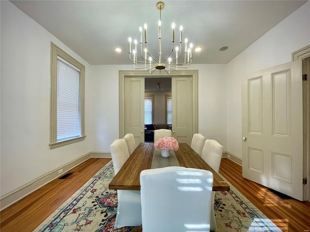 dining area with a chandelier and dark hardwood / wood-style floors