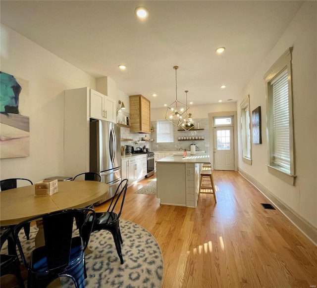 dining room featuring light wood-type flooring, an inviting chandelier, and sink