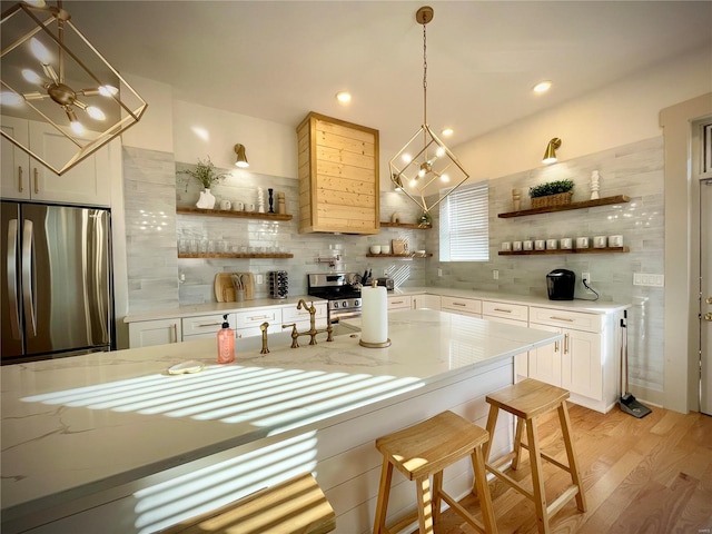 kitchen with a kitchen breakfast bar, light wood-type flooring, white cabinetry, and tasteful backsplash