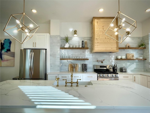 kitchen with white cabinetry, light stone countertops, tasteful backsplash, and stainless steel appliances