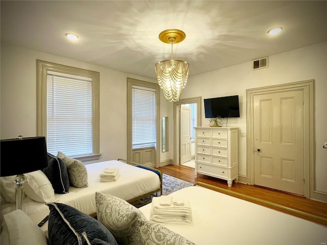 bedroom featuring a chandelier and wood-type flooring