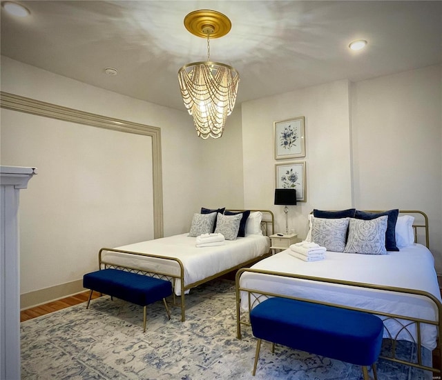 bedroom featuring wood-type flooring and an inviting chandelier