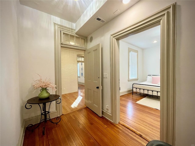 hall with plenty of natural light and hardwood / wood-style flooring