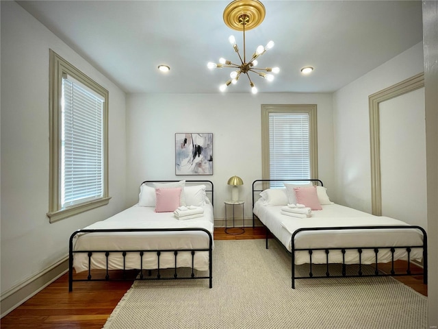 bedroom featuring hardwood / wood-style floors and a chandelier