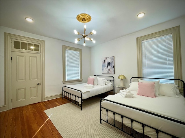 bedroom with a notable chandelier and dark hardwood / wood-style floors