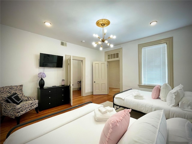 bedroom featuring wood-type flooring and a chandelier