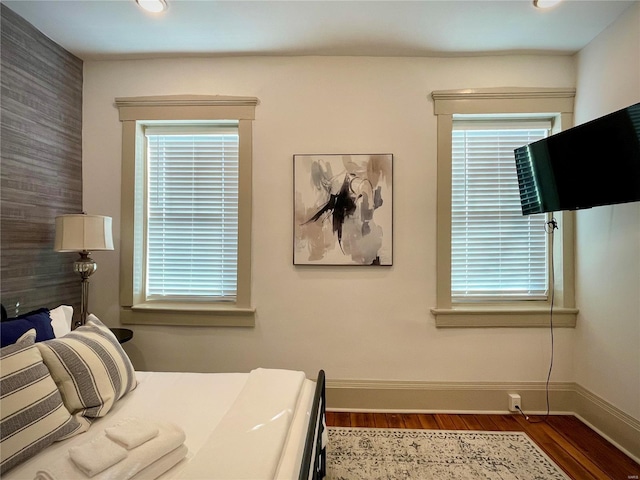 bedroom with dark hardwood / wood-style flooring