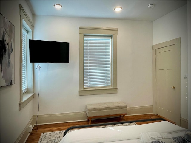 unfurnished bedroom featuring hardwood / wood-style floors and multiple windows