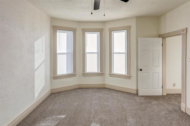 unfurnished room featuring carpet flooring, ceiling fan, and a textured ceiling