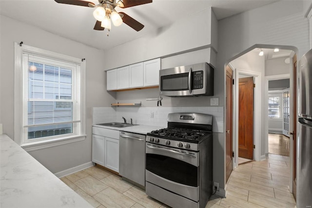 kitchen featuring appliances with stainless steel finishes, white cabinetry, and plenty of natural light