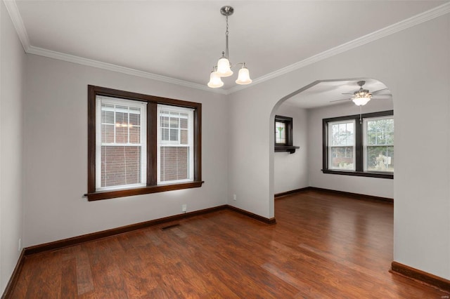 empty room with ceiling fan with notable chandelier, dark hardwood / wood-style floors, and ornamental molding