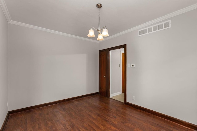 empty room featuring dark wood-type flooring, crown molding, and a notable chandelier