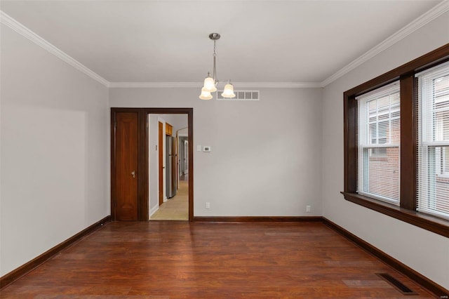 empty room featuring crown molding, dark wood-type flooring, and a chandelier