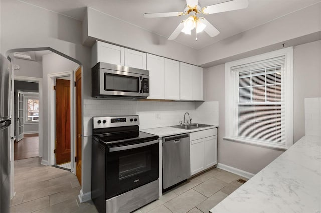 kitchen with white cabinets, sink, appliances with stainless steel finishes, and tasteful backsplash