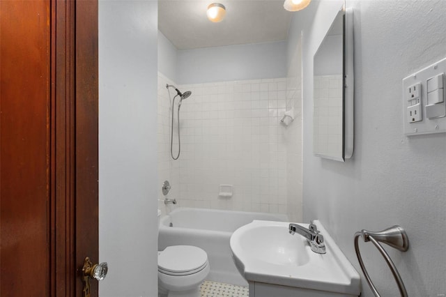 full bathroom featuring vanity, tiled shower / bath, and toilet