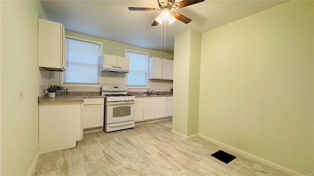 kitchen with white cabinetry, sink, gas range gas stove, and ceiling fan